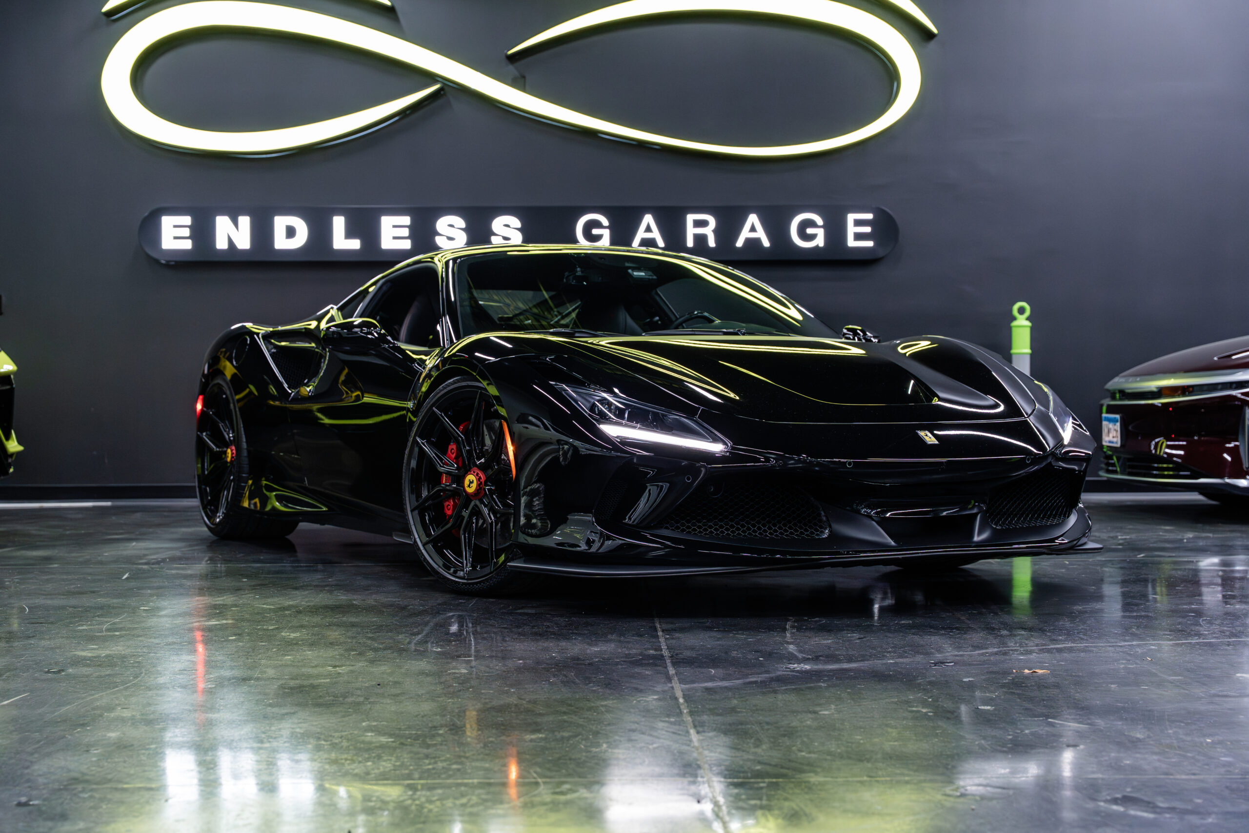 The 2018 Ferrari 488 GTB in sleek black finish, featuring a sporty design with aerodynamic curves and aggressive front grille. The car is presented in a modern garage setting, showcasing its striking presence.