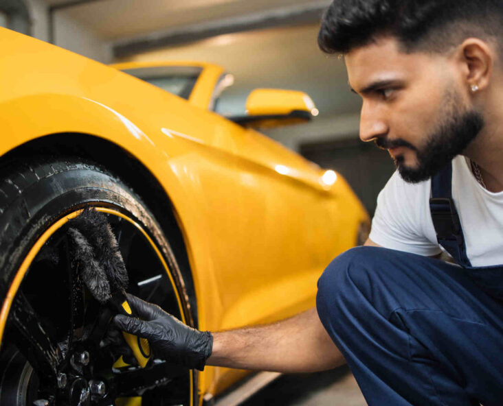 Worker providing luxury car maintenance in CO