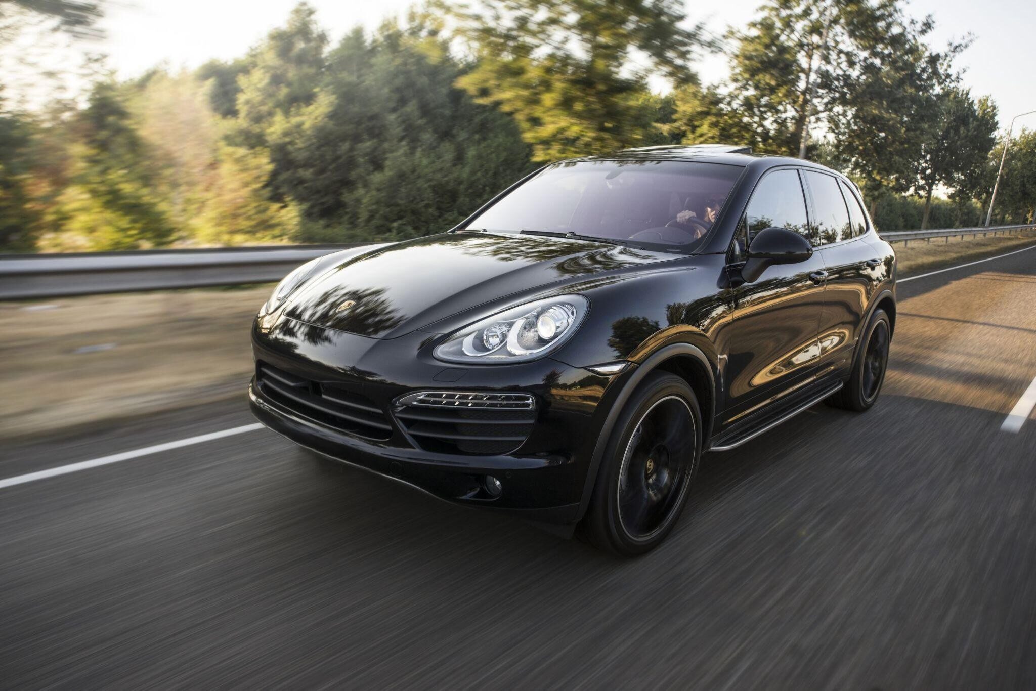 black porsche coup driving down a road