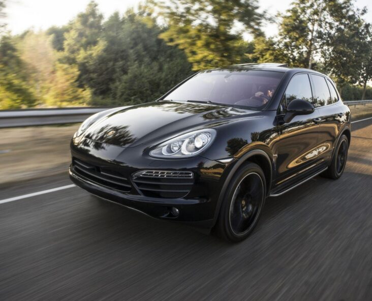 black porsche coup driving down a road