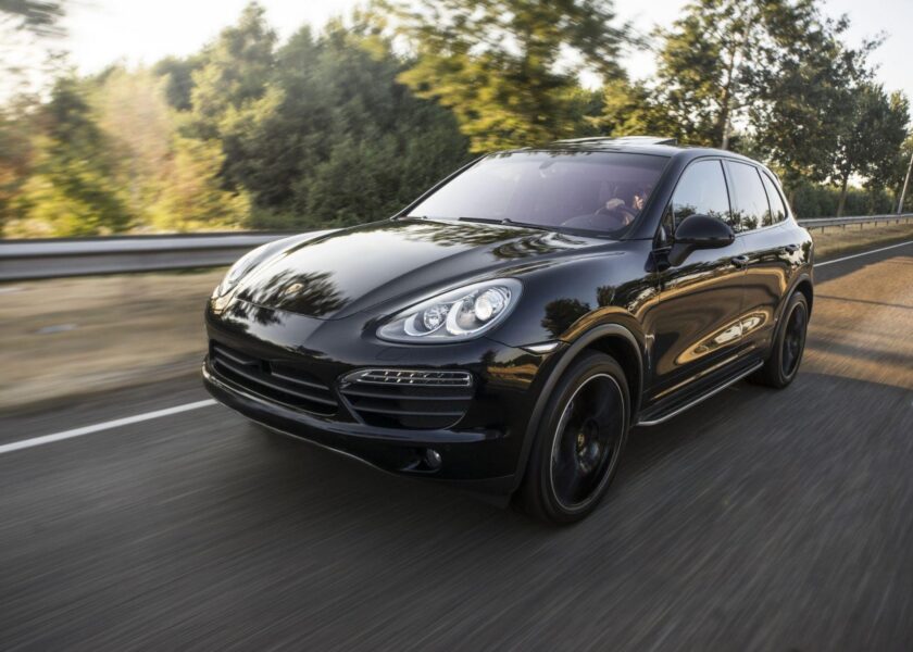 black porsche coup driving down a road